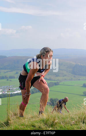 Signora cadde runner di affrontare una salita in forte pendenza in una gara cadde in un paese mostrano Foto Stock