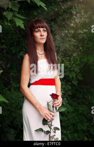 Ritratto di giovane e bella donna in abito bianco sulla natura Foto Stock