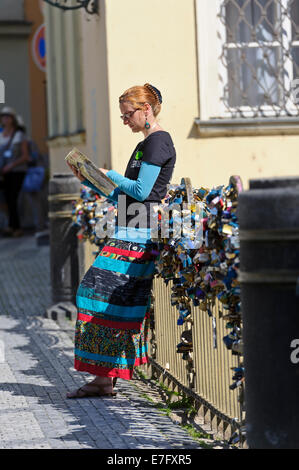 Un agente del Segway che conduce contro la ringhiera di un ponte coperto con una serie di lucchetti chiusi, Praga, Repubblica Ceca. Foto Stock