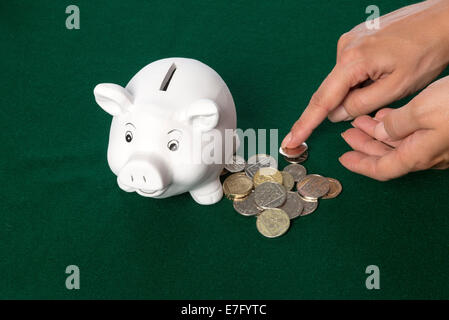 Salvadanaio di risparmio di denaro monete Britanniche per salvare essendo contati Foto Stock