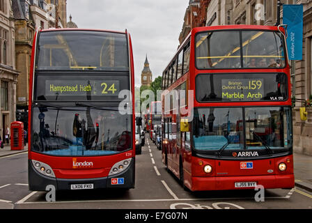 Due autobus rossi di Londra in attesa ad un semaforo con il Big Ben all'orizzonte. Foto Stock