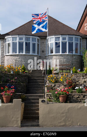 Regno Unito bandiere. La Union Jack e Scottish si intraversa volare al di sopra di un bungalow in Inghilterra durante il 2014 Scottish indipendenza campagna referendaria. Foto Stock