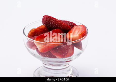 Fragole fresche tagliate a metà su sfondo bianco Foto Stock