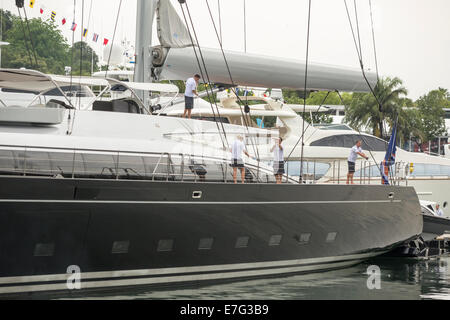 I membri dell'equipaggio il lavoro sulla Vertigo yacht a vela, fabbricato da Alloy Yachts Ltd., al Singapore Yacht Show 2014. Foto Stock