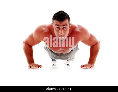 Muscolo uomo rendendo ups push in studio, isolate su uno sfondo bianco Foto Stock