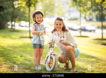 Ritratto di felice madre e bambina con noleggio biciclette Foto Stock