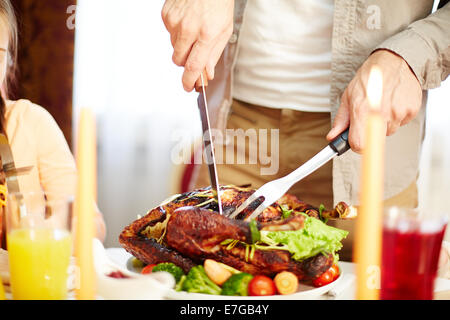 Gustoso arrosto di tacchino sulla piastra essendo tagliato da un uomo Foto Stock