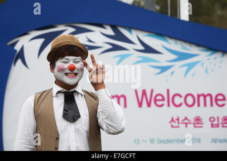 (140917) -- INCHEON, Sett. 17, 2014 (Xinhua) -- un personale vestito come un clown accoglie gli ospiti nel Villaggio Atleti in Incheon, Corea del Sud, Sett. 17, 2014. Il Villaggio Atleti è situato a dieci chilometri di distanza dalla principale premere Centro. Esso consiste di 22 edifici di appartamenti, che forniscono un totale di 2.200 camere. Xvii giochi asiatici che si terrà dal 7 settembre 19 ott. 4. (Xinhua/Zhang Fan)(Lz) Foto Stock