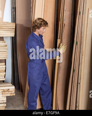 Carpenter disporre tavole di legno in officina Foto Stock