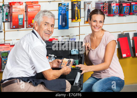 Venditore aiutare la donna nel negozio di ferramenta Foto Stock