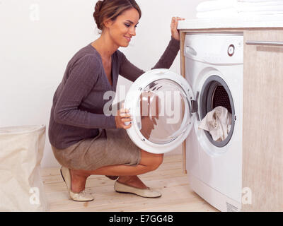 I lavori domestici, giovane donna facendo servizio lavanderia Foto Stock