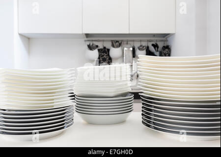 Pile di piatti puliti sul tavolo della cucina Foto Stock