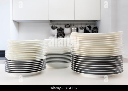 Pile di piatti puliti sul tavolo della cucina Foto Stock