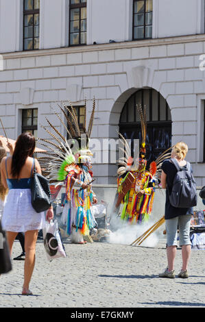 Due indiani degli artisti di strada in colorati costumi ballando nella parte anteriore del passante, Praga, Repubblica Ceca. Foto Stock