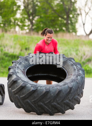 Atleta flipping carrello pneumatico all'aperto Foto Stock