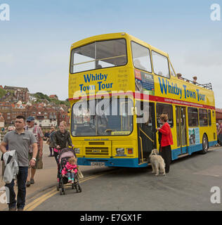 Giallo a sommità aperta double decker bus tour, popolare attrazione turistica in inglese città costiera di Whitby,con i passeggeri con il cane in attesa di bordo Foto Stock