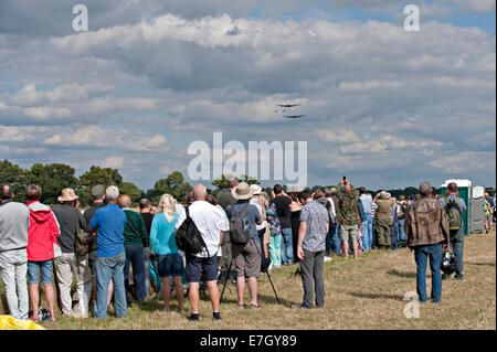 La folla guarda Headcorn, Kent come la Battaglia di Bretagna Memorial volo, comprese due WWII bombardieri Lancaster approccio Foto Stock