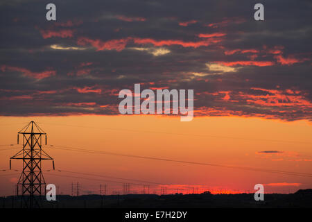 Torri di trasmissione che si staglia contro il cielo del tramonto Foto Stock