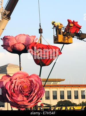 Pechino, Cina. Xviii Sep, 2014. Un lavoratore dispone le decorazioni di fiori per salutare la prossima Giornata nazionale del 1 ottobre a Piazza Tian'anmen a Pechino Capitale della Cina, Sett. 18, 2014. Credito: Xinhua/Alamy Live News Foto Stock