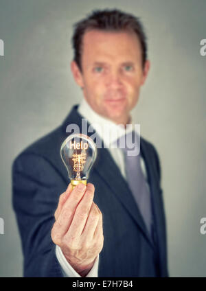Concetto di aiuto in una lampadina a filamento. Foto Stock