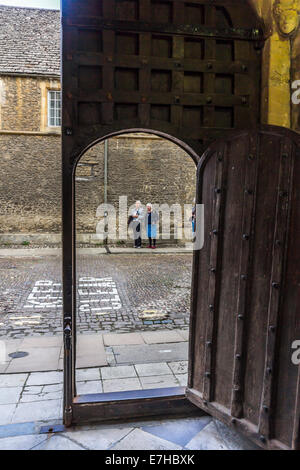 Portale ad arco con due signore in piedi sul lato opposto della strada, la porta è aperta Foto Stock