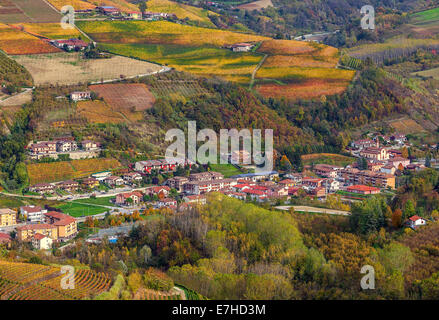 Piccola cittadina tra autunnale di colline e vigneti del Piemonte, Italia settentrionale (vista da sopra). Foto Stock