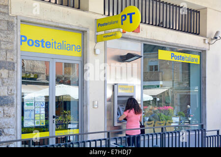 Donna che utilizza Postamat servizio ATM al di fuori di un Italiano post office in Taormina Taormina in provincia di Messina Sicilia Italia Foto Stock