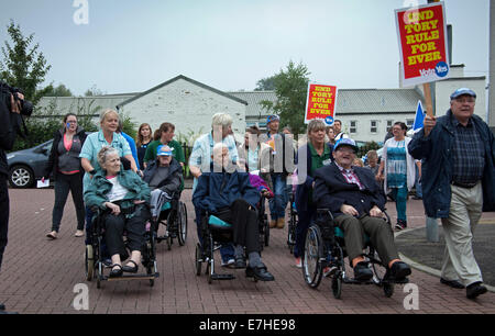 Craigmillar, Edimburgo, Scozia. Referendum scozzese. Xviii sett2014. Piper Ryan Rendell da Las Vegas con fiamme provenienti dalla sua cornamusa conduce la Pro-Independence residenti attraverso le strade di Craigmillar, Edimburgo, Scozia sulla'Short a piedi alla liberta' della locale stazione di polling per incoraggiare i residenti locali di voto. Manifesti per il marzo leggere: "The Pied Piper of Niddrie invita tutti sì agli elettori di prendere parte nel mese di marzo a breve distanza a piedi da libertà,' prima di aggiungere; ''andiamo tutti essere Bravehearts!' Foto Stock