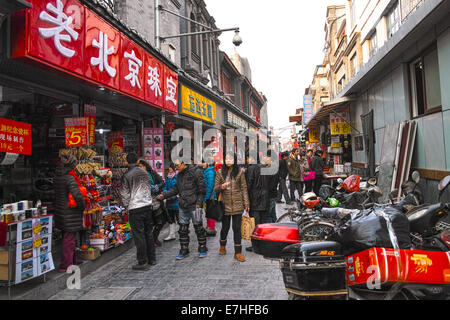Una vecchia Pechino Hutong piena di piccoli negozi e ristoranti Foto Stock
