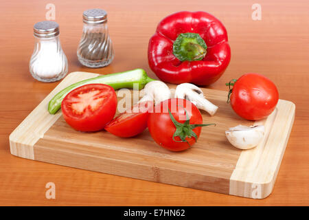 Ortaggi freschi per tutte le stagioni sul tagliere in cucina Foto Stock