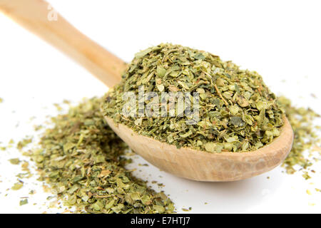 Origano secco spice sul cucchiaio di legno su sfondo bianco Foto Stock