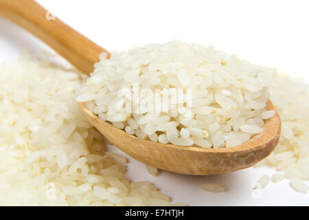 Grana di riso in legno vecchio cucchiaio isolati su sfondo bianco Foto Stock