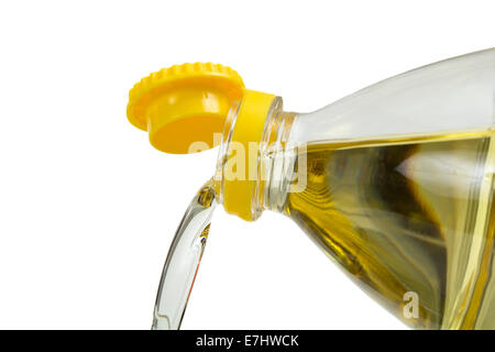 Olio di semi di girasole che viene versato di bottiglia in plastica isolate su sfondo bianco Foto Stock
