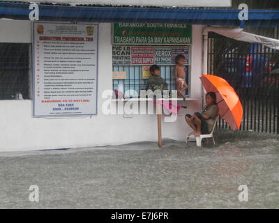 Una strada abitatori è stato intrappolato e il ricovero presso la stazione di polizia in Quezon Avenue nella città di Quezon come Mario tifone causato inondazioni nelle strade dovuta alla stima della sua pioggia di 7 - 20 mm per ora. © Sherbien Dacalanio/Pacific Press/Alamy Live News Foto Stock