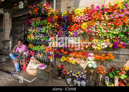 Un venditore ambulante è la vendita di coloratissimi fiori artificiali, Bhavnagar, Gujarat, India Foto Stock