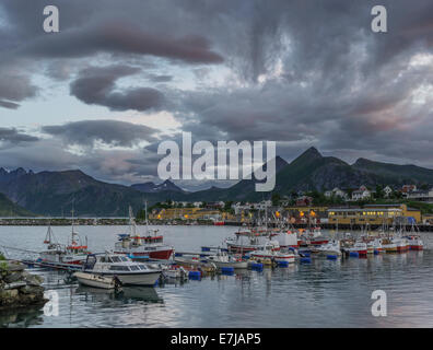 Le barche nel porto, il villaggio di pescatori di Husøy, Senja, Troms, Norvegia Foto Stock