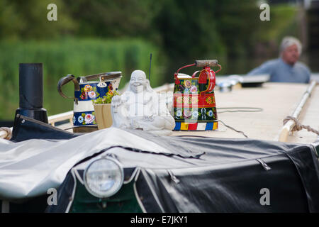 Caraffe in ceramica e statua del Buddha sulla barca stretta tetto chiatta narrowboat sul canale Kennet e Avon, Devizes, Wiltshire, Inghilterra, Regno Unito nel mese di agosto Foto Stock