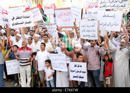 (140919) -- TRIPOLI, Sett. 19 (Xinhua) -- manifestanti tenere cartelloni e slogan chant durante un rally al martire Square a Tripoli, in Libia, il 7 settembre 19, 2014. Centinaia di persone hanno preso per strada a Tripoli per mostrare il loro sostegno per gli islamisti-backed Primo Ministro Omar al-Hasi. Dal mese di luglio, la Libia è stata la giocoleria due governi rivali, uno guidato da Hasi islamista e un altro quello diretto da pro-secular Abdullah al-Thinni, che ora è in esilio in Libia orientale della città di Tobruk. (Xinhua/Hamza Turkia) Foto Stock