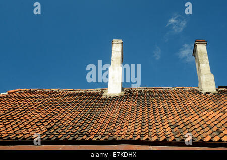 Il vecchio tetto di tegole sul cielo blu sullo sfondo Foto Stock