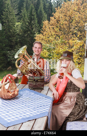 Coppia giovane in tradizionali abiti bavarese godetevi il vostro tempo libero in comune Foto Stock