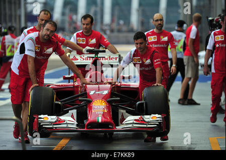 Singapore. Xx Settembre, 2014. Il team Ferrari pit crew spingere l'auto al garage del team prima della terza sessione di prove libere a Singapore F1 gara in notturna a Singapore il 7 settembre 20, 2014. Credito: Quindi Chih Wey/Xinhua/Alamy Live News Foto Stock