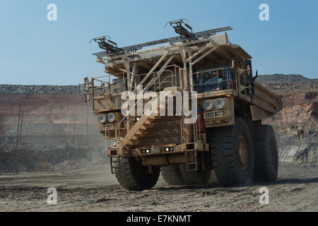 Un bianco massiccio ibrido diesel elettrico/dump Hitatchi carrello procede lungo il pavimento di un africano a cielo aperto miniera di rame. Foto Stock