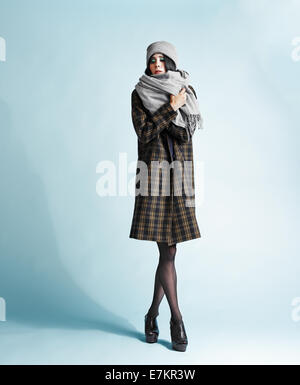 A piena lunghezza Ritratto di giovane e bella donna che indossa un soprabito - studio shot Foto Stock