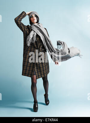 A piena lunghezza Ritratto di giovane e bella donna che indossa un soprabito - studio shot Foto Stock