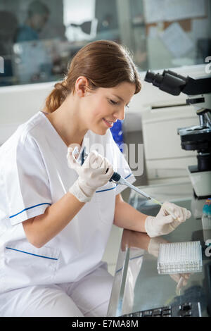 Scienziato usando una pipetta in laboratorio Foto Stock