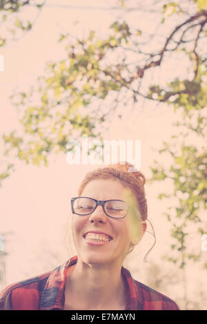 Hipster ragazza cercando felice con un grande sorriso toothy godendo il giorno all'aperto Foto Stock