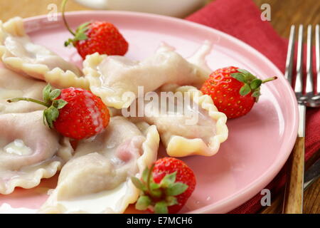 Gnocchi di patate con frutti di bosco e salsa panna con fragole fresche Foto Stock