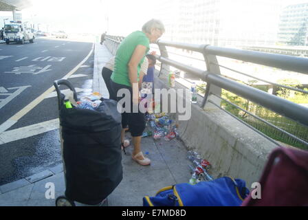 Con i nonni la raccolta dei rifiuti bambina in Cina Foto Stock