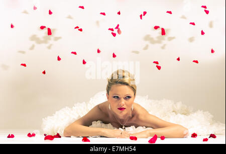 Bella Sposa, posa , con fiori e petali di rose. Foto Stock