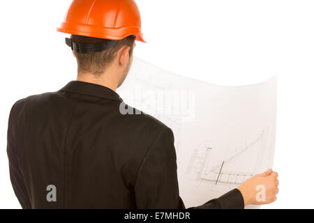 Al di sopra della spalla di un giovane architetto in un vestito e un hardhat in piedi con la schiena per la fotocamera a studiare un edificio blueprint ,su bianco. Foto Stock